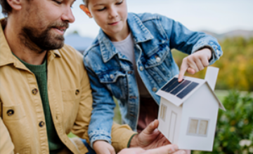 Padre e hijo con una casa de papel en las manos